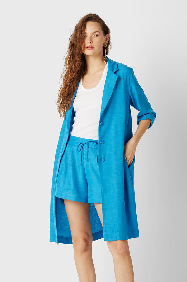 Brunette Model wearing the lady & the sailor Midi Blazer in Turquoise.
