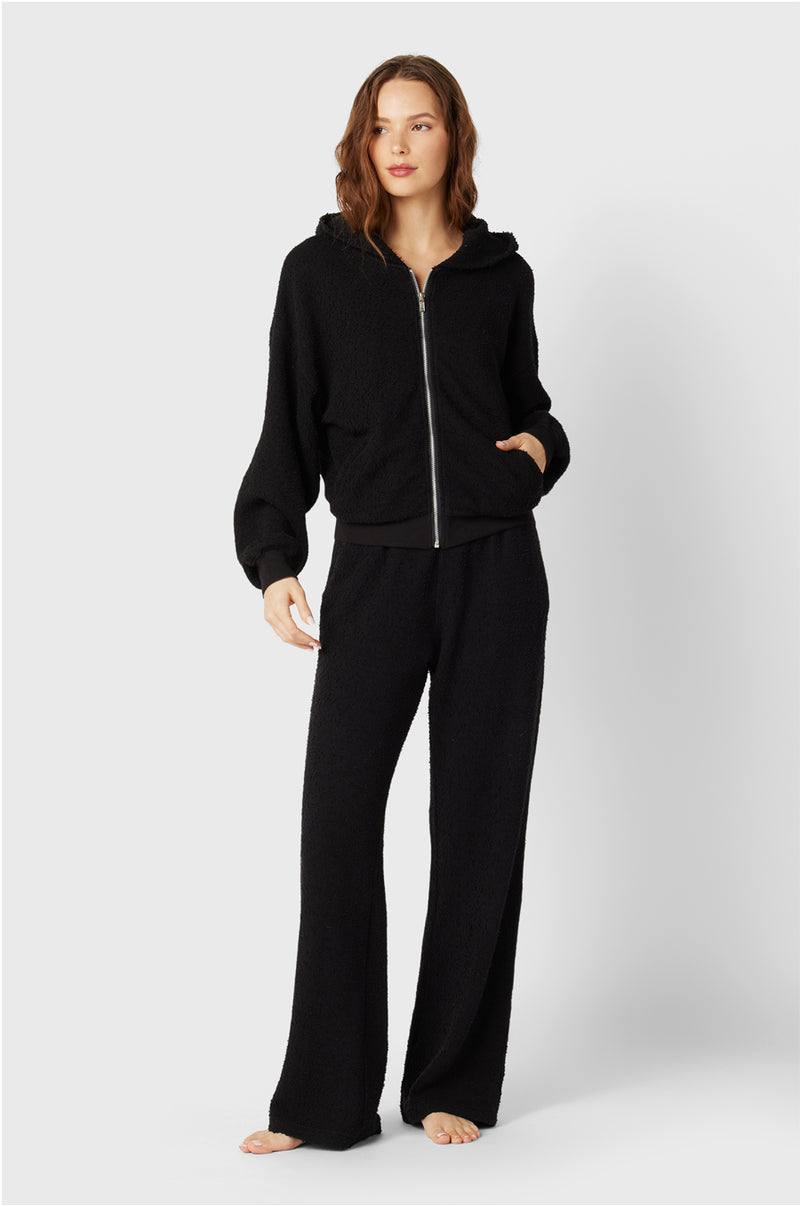 Brunette Model wearing the lady & the sailor the Straight Leg Sweatpant in Black Boucle.