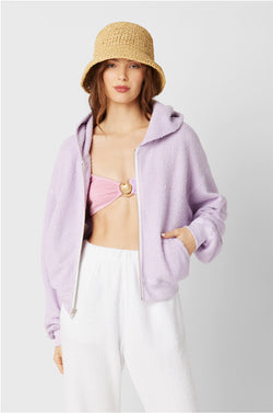 Brunette Model wearing the lady & the sailor the Zip Up Hoodie in Lilac Boucle.