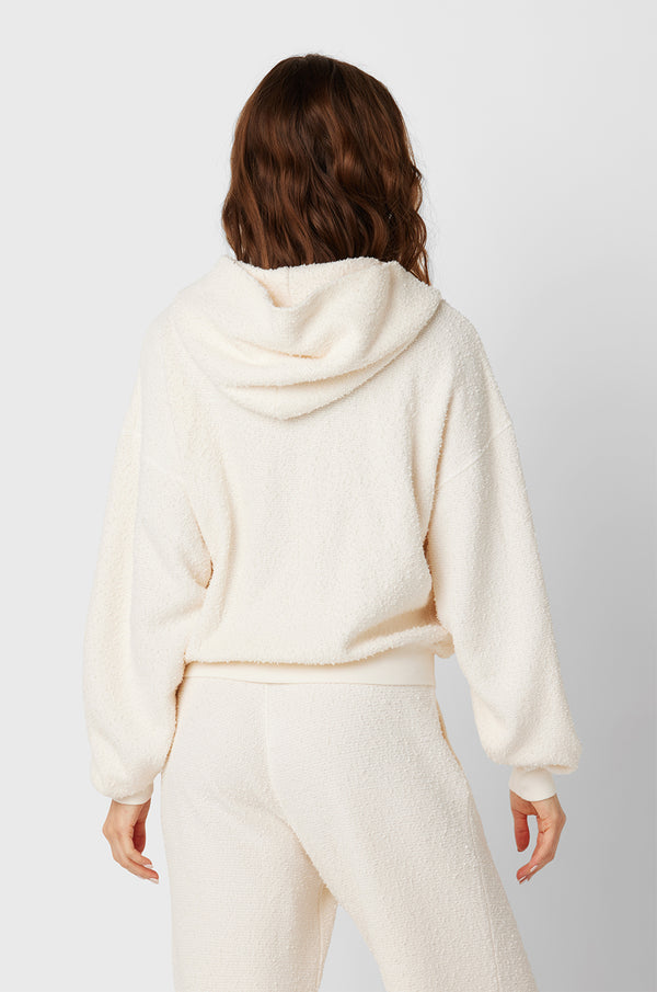 Brunette Model wearing the lady & the sailor the Zip Up Hoodie in Vanilla Boucle.