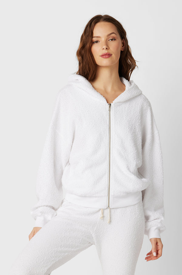 Brunette Model wearing the lady & the sailor the Zip Up Hoodie in White Boucle.