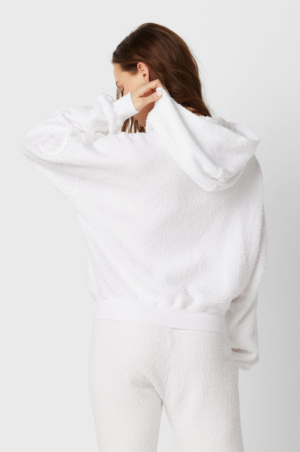 Brunette Model wearing the lady & the sailor the Zip Up Hoodie in White Boucle.