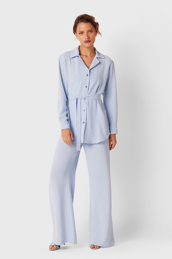 Brunette Model wearing the lady & the sailor Belted Button Up in Glacier Air Flow.