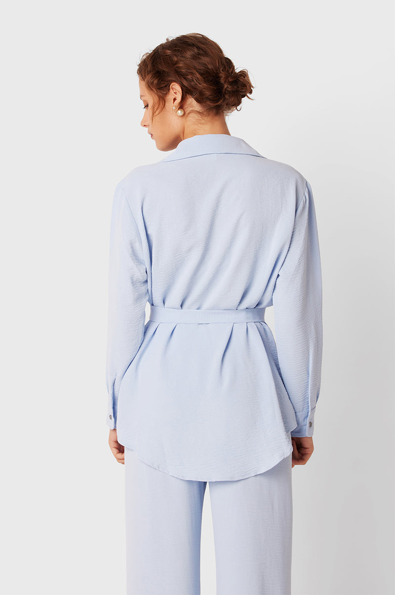 Brunette Model wearing the lady & the sailor Belted Button Up in Glacier Air Flow.