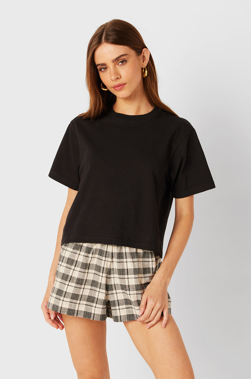 Brunette Model wearing the lady & the sailor Smock Band Shorts in Black Plaid. 