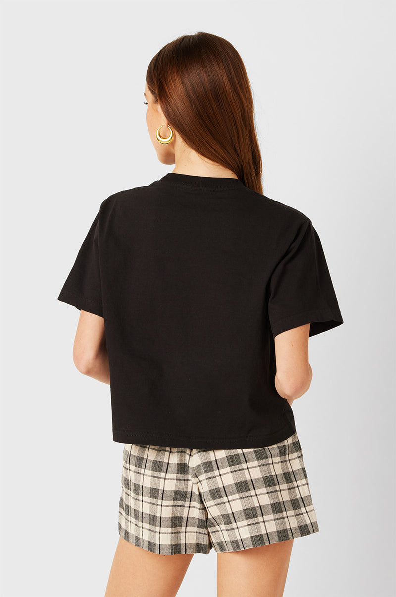 Brunette Model wearing the lady & the sailor Smock Band Shorts in Black Plaid. 