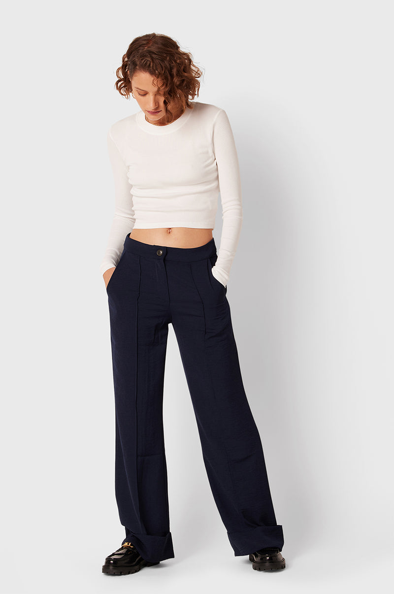 Brunette Model wearing the lady & the sailor Long Sleeve Cropped Tee in White Classic Rib.