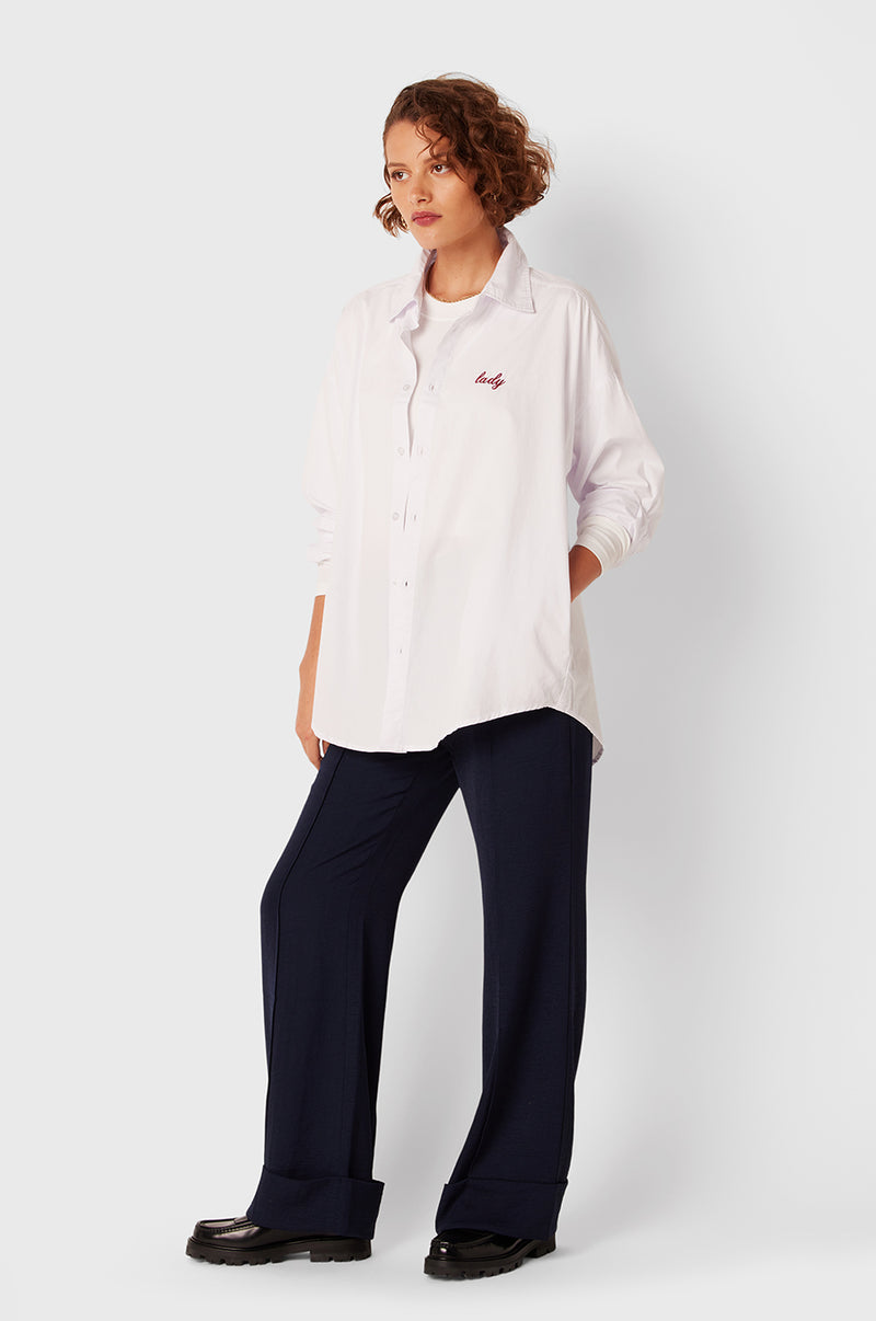 Brunette Model wearing the lady & the sailor Lady Button Up in White Cotton Poplin/Ruby.