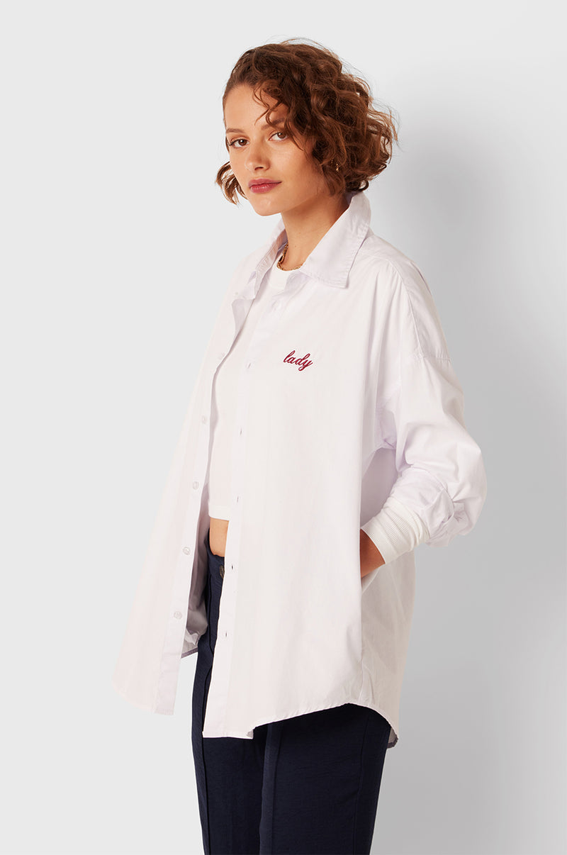 Brunette Model wearing the lady & the sailor Lady Button Up in White Cotton Poplin/Ruby.