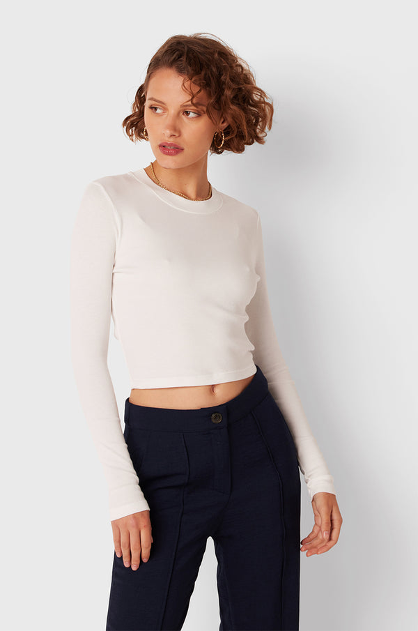 Brunette Model wearing the lady & the sailor Long Sleeve Cropped Tee in White Classic Rib.