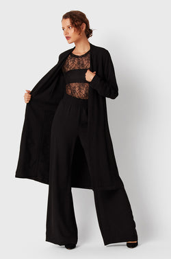 Brunette Model wearing the lady & the sailor Midi Duster Coat in Black Air Flow.