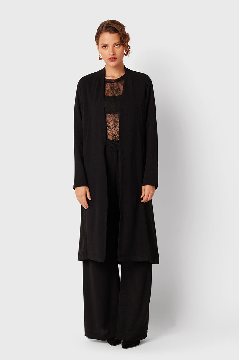 Brunette Model wearing the lady & the sailor Smock Band Pants in Black Air Flow.