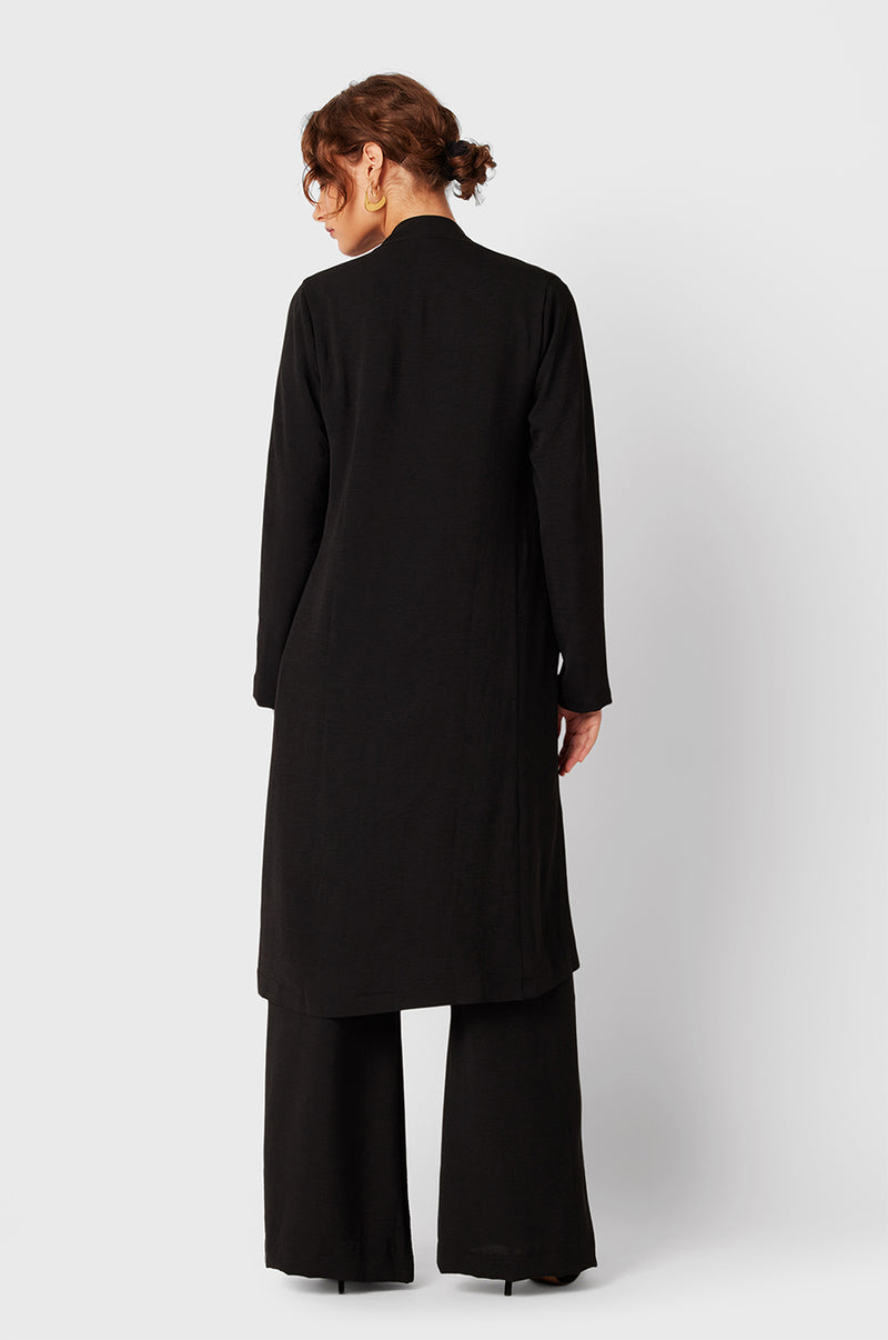 Brunette Model wearing the lady & the sailor Smock Band Pants in Black Air Flow.