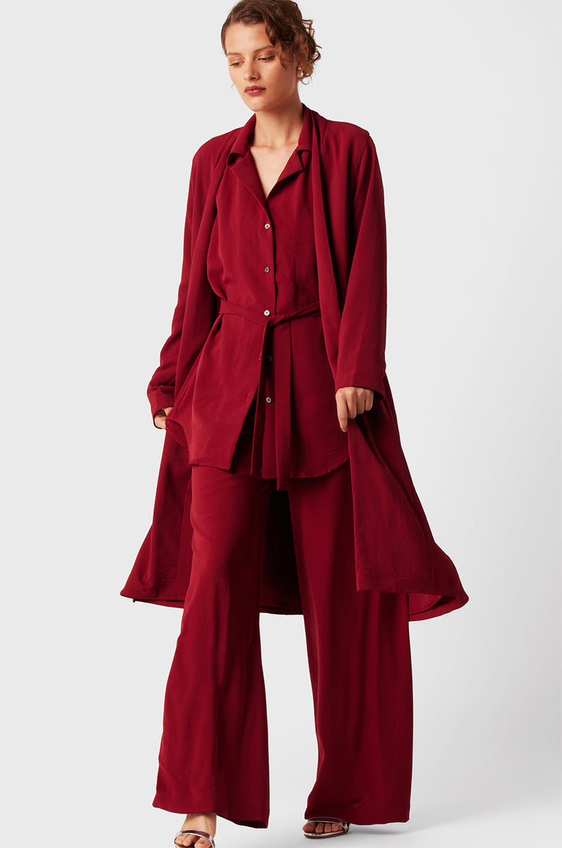 Brunette Model wearing the lady & the sailor Midi Duster Coat in Ruby Air Flow.