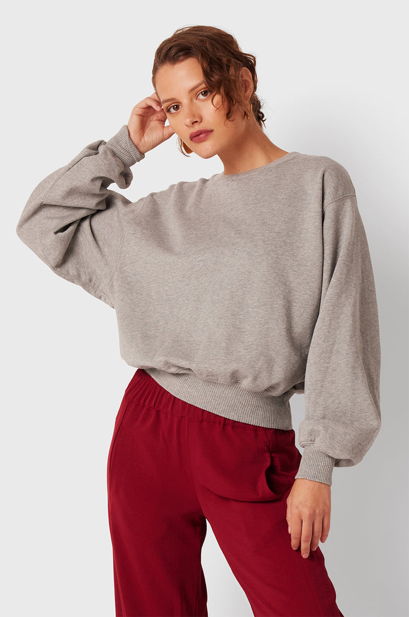 Brunette Model wearing the lady & the sailor The Kristin Sweatshirt in Heather Grey Fleece.