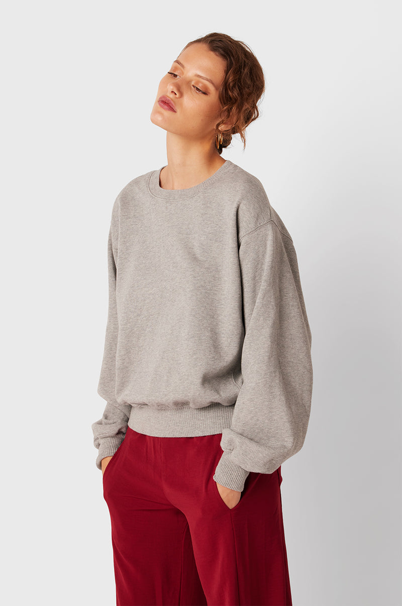 Brunette Model wearing the lady & the sailor The Kristin Sweatshirt in Heather Grey Fleece.