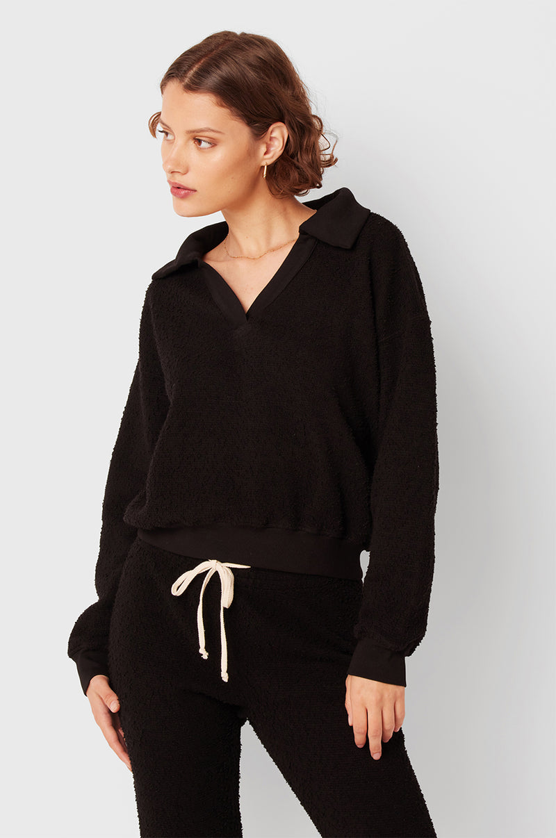 Brunette Model wearing the lady & the sailor Polo Sweatshirt in Black Boulcé.