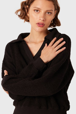 Brunette Model wearing the lady & the sailor Polo Sweatshirt in Black Boulcé.