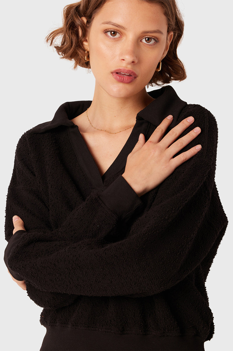Brunette Model wearing the lady & the sailor Polo Sweatshirt in Black Boulcé.