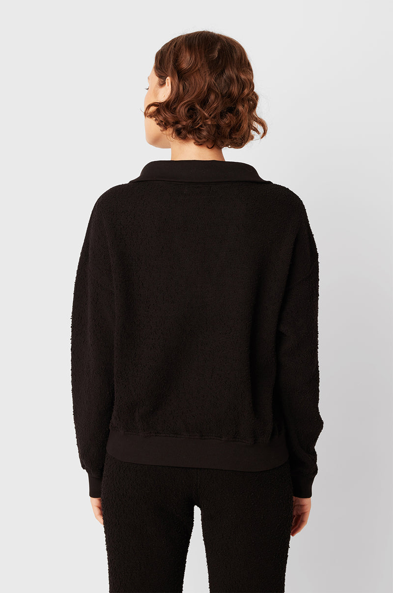 Brunette Model wearing the lady & the sailor Polo Sweatshirt in Black Boulcé.