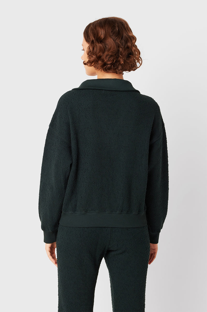 Brunette Model wearing the lady & the sailor Polo Sweatshirt in Evergreen Boulcé.