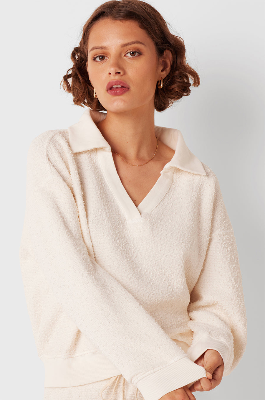 Brunette Model wearing the lady & the sailor Polo Sweatshirt in Vanilla Boulcé.