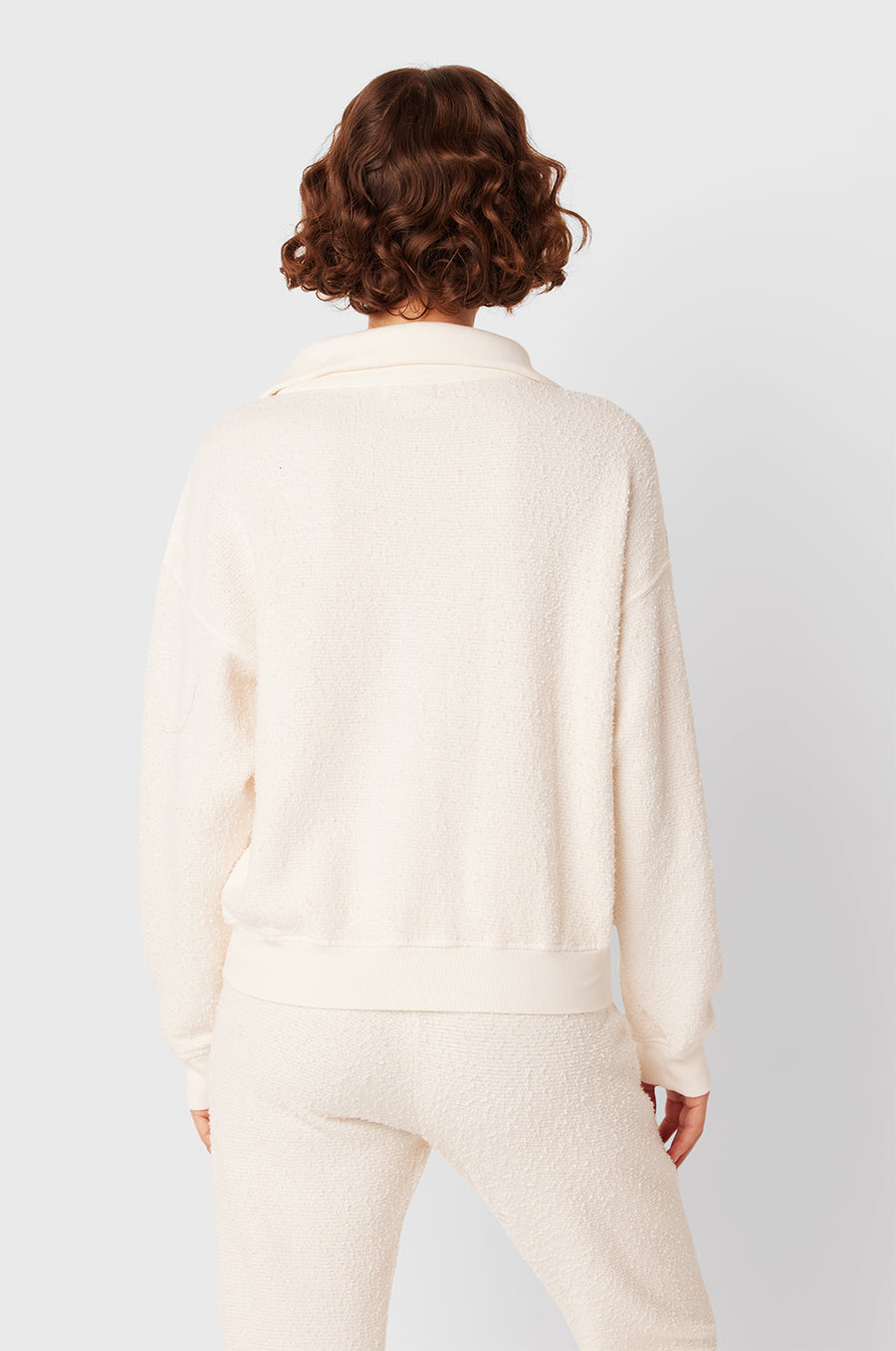 Brunette Model wearing the lady & the sailor Polo Sweatshirt in Vanilla Boulcé.