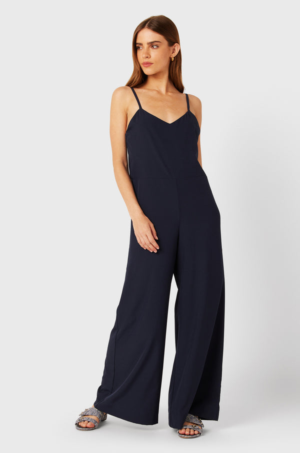 Brunette Model wearing the lady & the sailor Relaxed Jumpsuit in Navy.