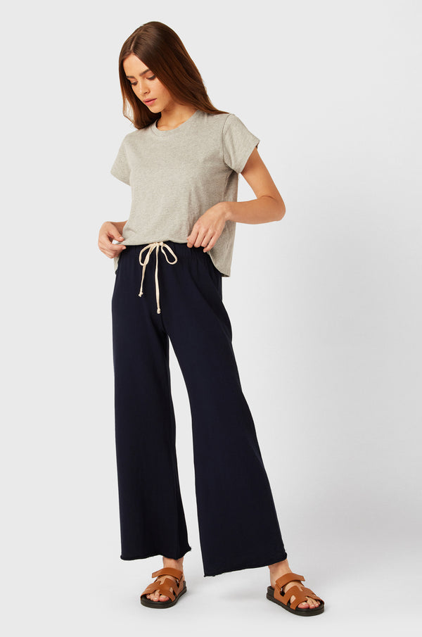 Brunette Model wearing the lady & the sailor French Flare Pant in Navy Organic Cotton.