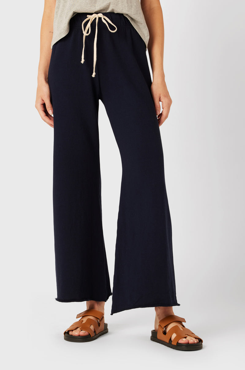 Brunette Model wearing the lady & the sailor French Flare Pant in Navy Organic Cotton.