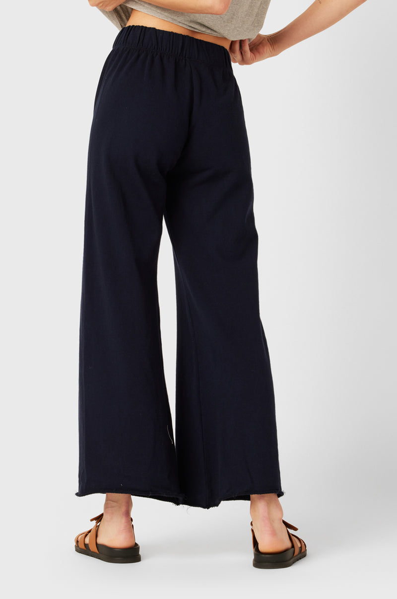 Brunette Model wearing the lady & the sailor French Flare Pant in Navy Organic Cotton.