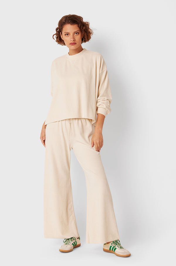 Brunette Model wearing the lady & the sailor The Slouchy Sweatshirt in Ivory Cord.