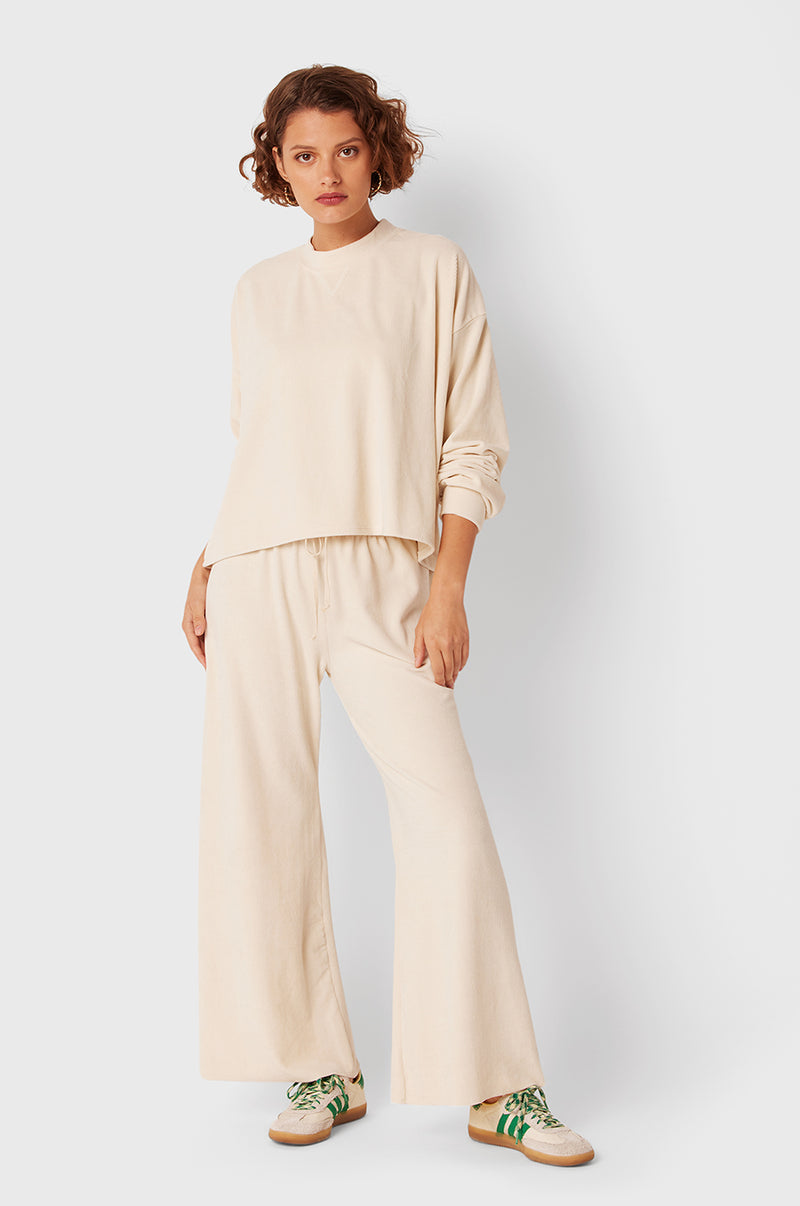 Brunette Model wearing the lady & the sailor The Slouchy Sweatshirt in Ivory Cord.