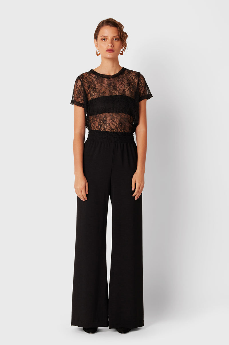 Brunette Model wearing the lady & the sailor Smock Band Pants in Black Air Flow.