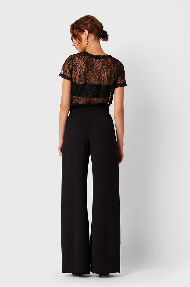 Brunette Model wearing the lady & the sailor Smock Band Pants in Black Air Flow.