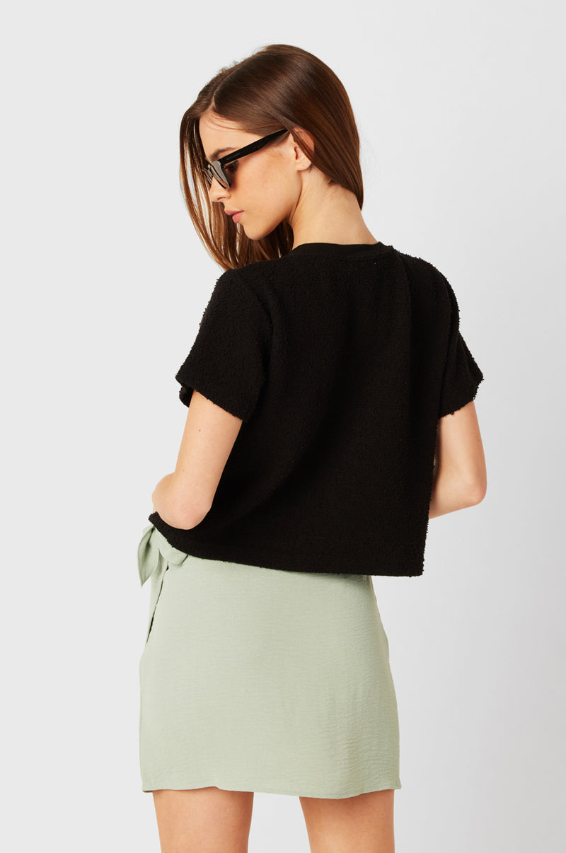 Brunette Model wearing the lady & the sailor Wrap Mini Skirt in Seaglass Air Flow.