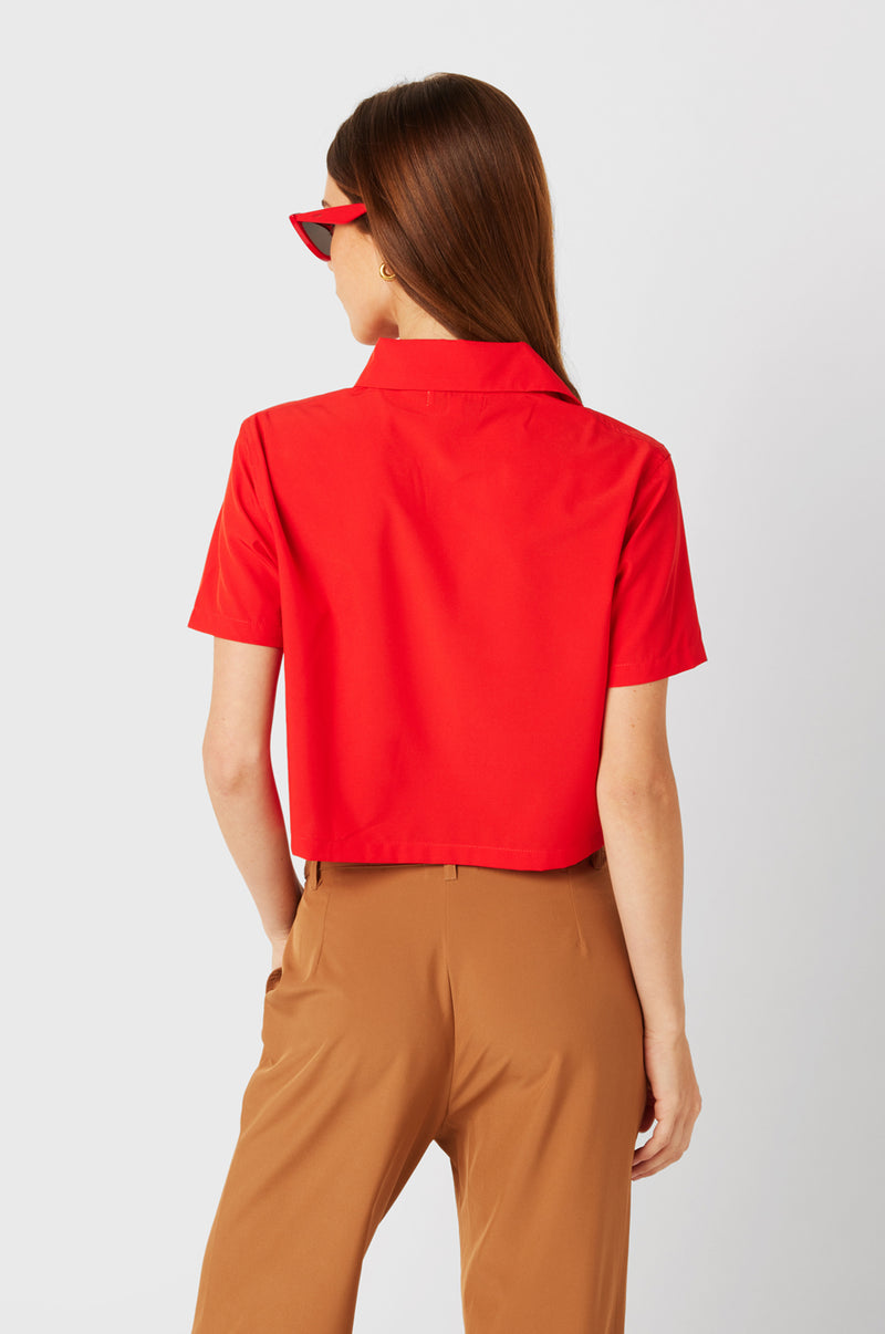 Brunette Model wearing the lady & the sailor SS Polo Blouse in Geranium.