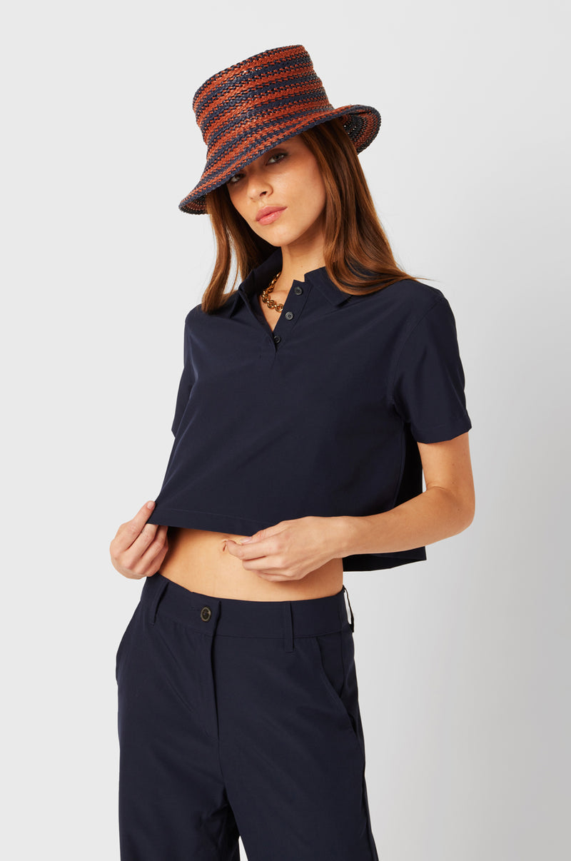 Brunette Model wearing the lady & the sailor SS Polo Blouse in Navy.