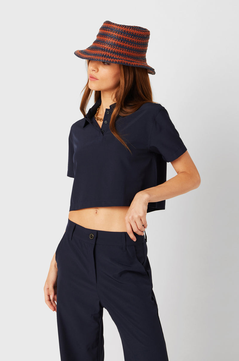 Brunette Model wearing the lady & the sailor SS Polo Blouse in Navy.