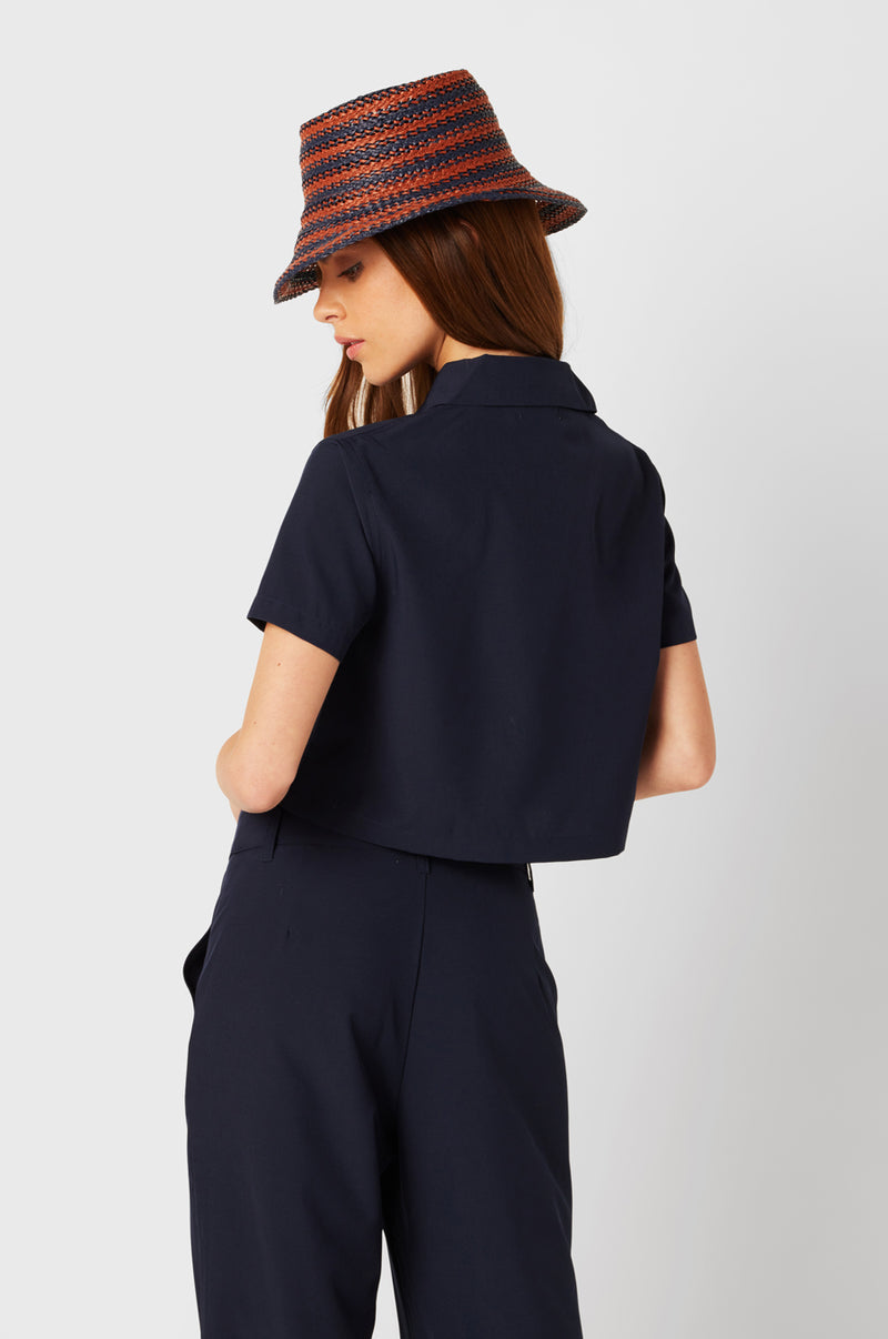 Brunette Model wearing the lady & the sailor SS Polo Blouse in Navy.