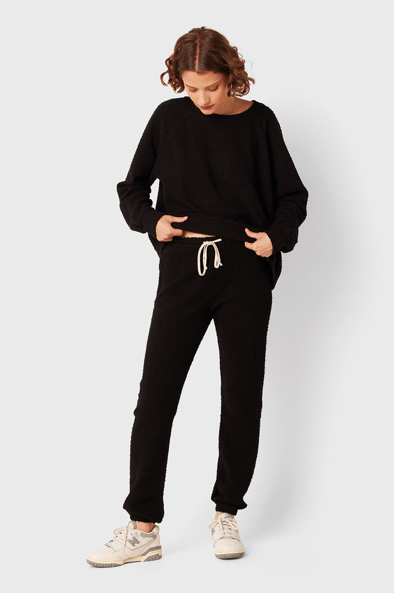 Brunette Model wearing the lady & the sailor Full Length Vintage Sweatpant in Black Bouclé.