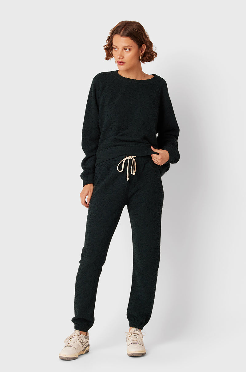 Brunette Model wearing the lady & the sailor Full Length Vintage Sweatpant in Evergreen Bouclé.