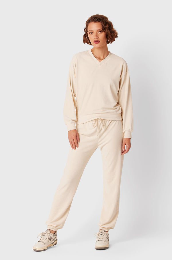 Brunette Model wearing the lady & the sailor Full Length Vintage Sweatpant in Ivory Cord.