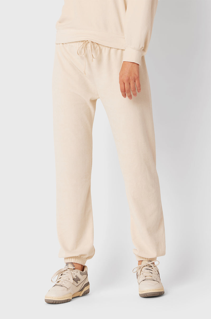 Brunette Model wearing the lady & the sailor Full Length Vintage Sweatpant in Ivory Cord.