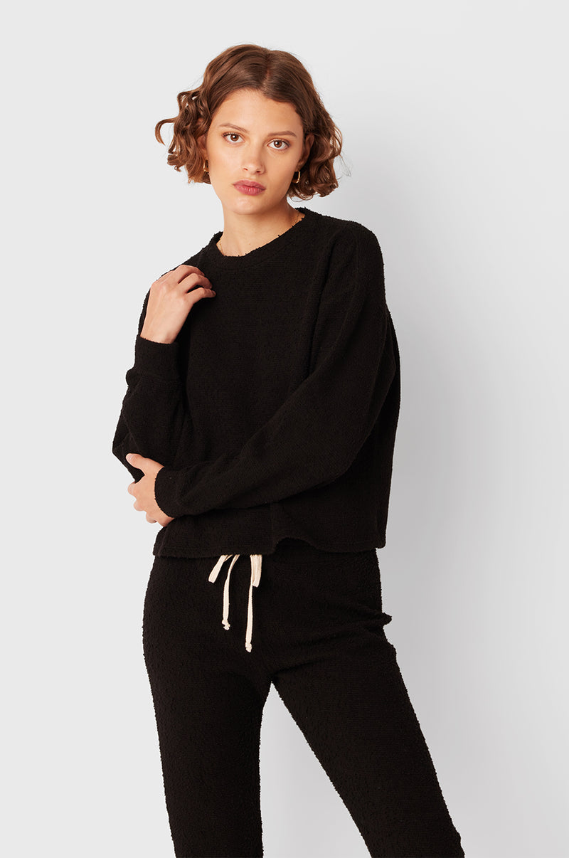 Brunette Model wearing the lady & the sailor Full Length Vintage Sweatpant in Black Bouclé.